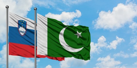 Slovenia and Pakistan flag waving in the wind against white cloudy blue sky together. Diplomacy concept, international relations.