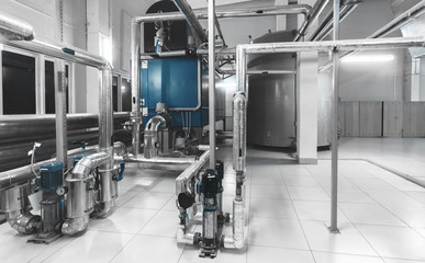 interior of modern industrial boiler room with boilers, pumps, pressure gauges and pipes for gas...