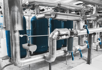 Modern industrial boiler room. Water treatment pipes and pressure gauges installed for pressure control. Water treatment device. Blue toning