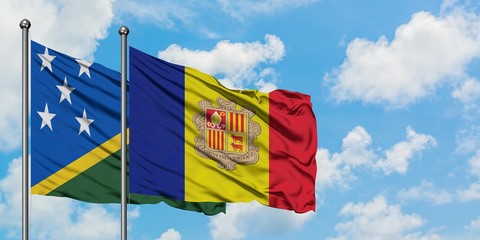 Solomon Islands and Andorra flag waving in the wind against white cloudy blue sky together....