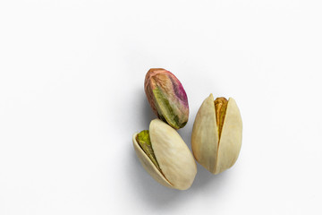 Obraz na płótnie Canvas Three pistachio nuts lie on a white background