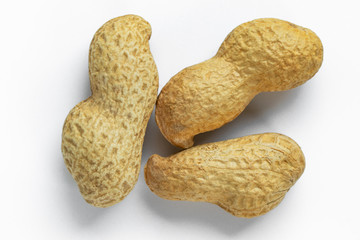 Three peanuts in shell lie on a white background