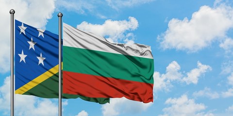 Solomon Islands and Bulgaria flag waving in the wind against white cloudy blue sky together. Diplomacy concept, international relations.