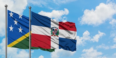 Solomon Islands and Dominican Republic flag waving in the wind against white cloudy blue sky together. Diplomacy concept, international relations.