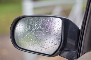 car side mirror with water drops close up