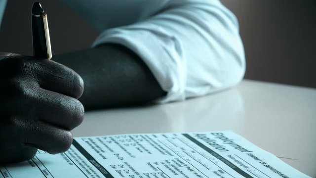 Closeup on black Hand Filling in  job Application Form for.Job,migration