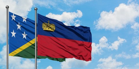 Solomon Islands and Liechtenstein flag waving in the wind against white cloudy blue sky together. Diplomacy concept, international relations.