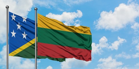 Solomon Islands and Lithuania flag waving in the wind against white cloudy blue sky together. Diplomacy concept, international relations.