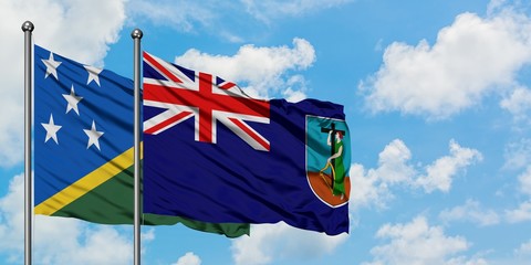 Solomon Islands and Montserrat flag waving in the wind against white cloudy blue sky together....