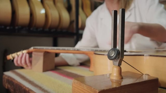 Lutemaker At Work And Tuning Guitar In Music Lab