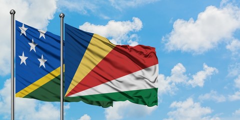 Solomon Islands and Seychelles flag waving in the wind against white cloudy blue sky together. Diplomacy concept, international relations.