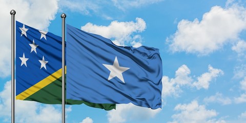 Solomon Islands and Somalia flag waving in the wind against white cloudy blue sky together. Diplomacy concept, international relations.