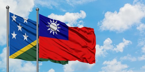Solomon Islands and Taiwan flag waving in the wind against white cloudy blue sky together. Diplomacy concept, international relations.