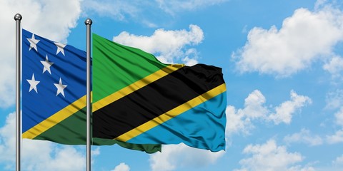 Solomon Islands and Tanzania flag waving in the wind against white cloudy blue sky together. Diplomacy concept, international relations.