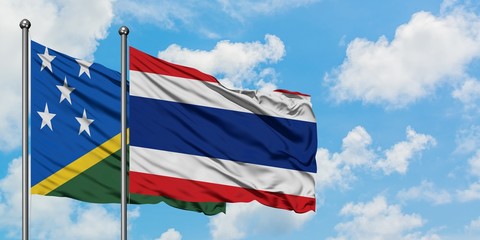 Solomon Islands and Thailand flag waving in the wind against white cloudy blue sky together. Diplomacy concept, international relations.