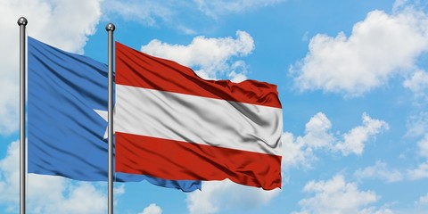 Somalia and Austria flag waving in the wind against white cloudy blue sky together. Diplomacy concept, international relations.