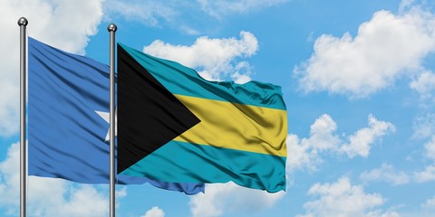 Somalia and Bahamas flag waving in the wind against white cloudy blue sky together. Diplomacy concept, international relations.