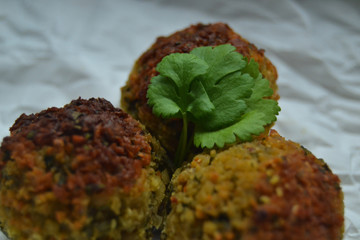 Falafel on white paper. vegan food on a white background. fresh vegan tasty falafel with spices, falafel baked in the oven. chickpeas balls. a source of protein for vegans. 