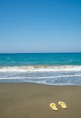 Yellow sandals on a golden sandy beach