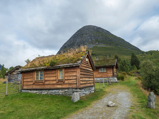 Fototapeta na wymiar Traditional Scandinavian wooden cabins sod or turf roof house at a campsite in the Reinheim national Park. View from scenic road 63, Norway.