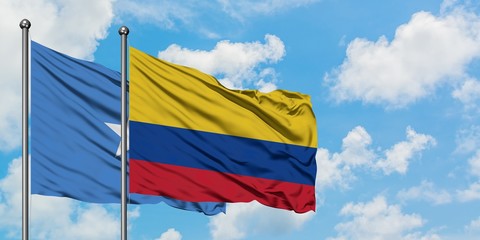 Somalia and Colombia flag waving in the wind against white cloudy blue sky together. Diplomacy concept, international relations.
