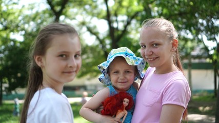 Fototapeta na wymiar Portrait of three girls posing in a park in the summer