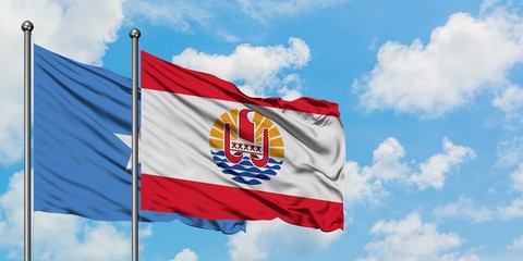 Somalia and French Polynesia flag waving in the wind against white cloudy blue sky together. Diplomacy concept, international relations.