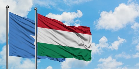 Somalia and Hungary flag waving in the wind against white cloudy blue sky together. Diplomacy concept, international relations.