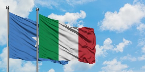 Somalia and Italy flag waving in the wind against white cloudy blue sky together. Diplomacy concept, international relations.