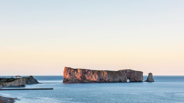 Timelapse of Rocher Perce rock sunset in Gaspe Peninsula, Quebec, Gaspesie region, Canada, Saint Lawrence gulf water waves cinemagraph loop of famous arch
