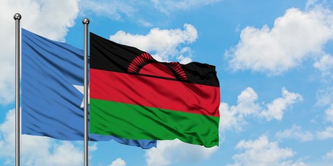 Somalia and Malawi flag waving in the wind against white cloudy blue sky together. Diplomacy concept, international relations.