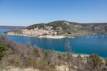 An overview of Lake Saint Croix with mountains and  the village of Bauduen in the background. 