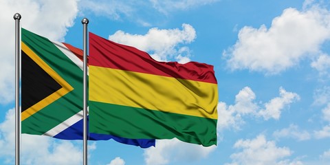 South Africa and Bolivia flag waving in the wind against white cloudy blue sky together. Diplomacy concept, international relations.