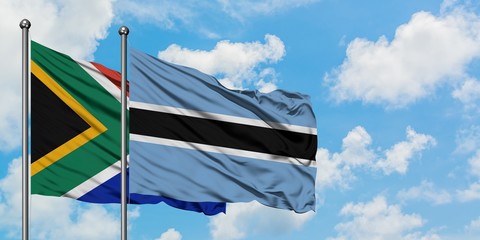 South Africa and Botswana flag waving in the wind against white cloudy blue sky together. Diplomacy...