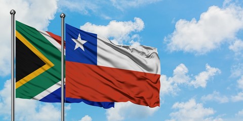 South Africa and Chile flag waving in the wind against white cloudy blue sky together. Diplomacy concept, international relations.