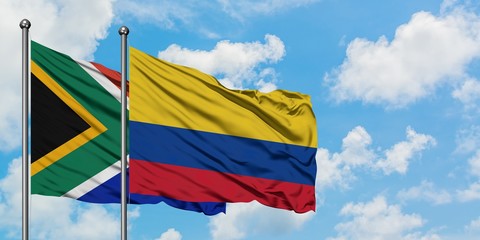 South Africa and Colombia flag waving in the wind against white cloudy blue sky together. Diplomacy concept, international relations.