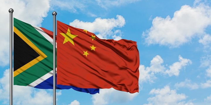 South Africa and China flag waving in the wind against white cloudy blue sky together. Diplomacy concept, international relations.