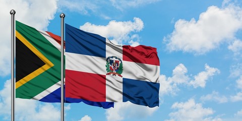 South Africa and Dominican Republic flag waving in the wind against white cloudy blue sky together. Diplomacy concept, international relations.