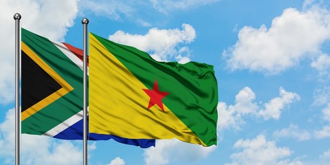 South Africa and French Guiana flag waving in the wind against white cloudy blue sky together. Diplomacy concept, international relations.