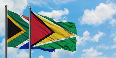 South Africa and Guyana flag waving in the wind against white cloudy blue sky together. Diplomacy concept, international relations.