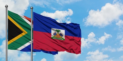 South Africa and Haiti flag waving in the wind against white cloudy blue sky together. Diplomacy concept, international relations.
