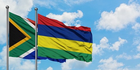 South Africa and Mauritius flag waving in the wind against white cloudy blue sky together. Diplomacy concept, international relations.