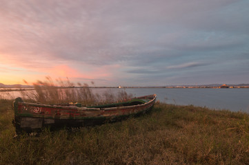Abandoned boat in front of a lake