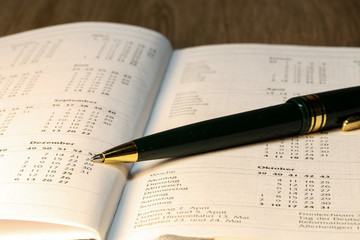 Pen lying on calendar or organizer on desk in office