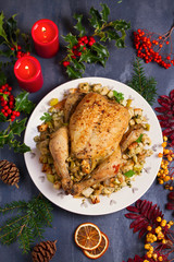 Roasted chicken with apple and bread stuffing. Christmas decorations. Dish for Christmas Eve. New Year food menu. Flat lay, view from above