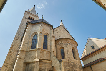 Fototapeta na wymiar Church from beige bricks with large windows against the blue sky on a bright sunny day in Prague, Czech Republic.