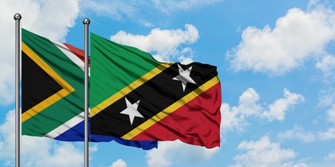 South Africa and Saint Kitts And Nevis flag waving in the wind against white cloudy blue sky together. Diplomacy concept, international relations.