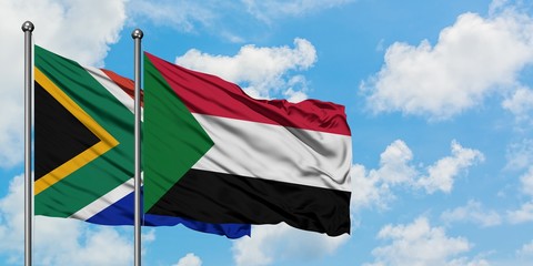 South Africa and Sudan flag waving in the wind against white cloudy blue sky together. Diplomacy concept, international relations.