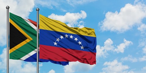 South Africa and Venezuela flag waving in the wind against white cloudy blue sky together. Diplomacy concept, international relations.