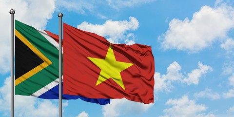 South Africa and Vietnam flag waving in the wind against white cloudy blue sky together. Diplomacy concept, international relations.
